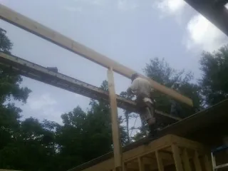 Carpenter setting a ridge beam over a new addition frame — Ice Dam Removal by Roofing Brothers in Loysburg