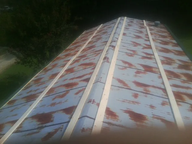 Rusted metal roof panels with new wood purlins before replacement — Storm Damage Roof Repair in Loysburg by Roofing Brothers